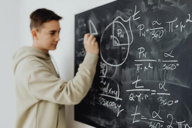 boy writing on a blackboard